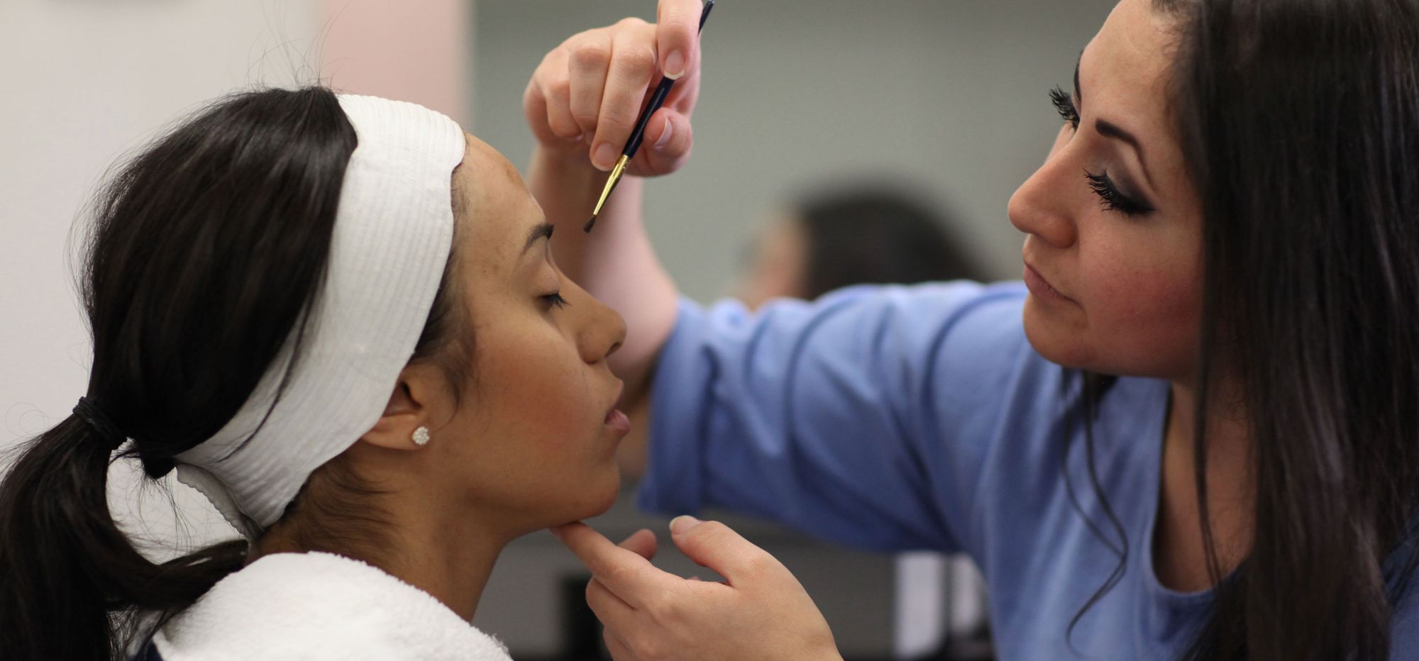 Cosmetology students at the Central California Women's Facility practice applying makeup during a lesson in 2017.
