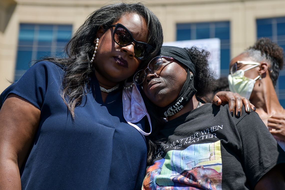 Colorado state representative Leslie Herod, left, hugs Elijah McClain's mother, Sheneen McClain, right, as they stand with protesters as they rally outside the Aurora Police Department Headquarters to demand justice for McClain's son on June 27, 2020 in Aurora, Colorado.