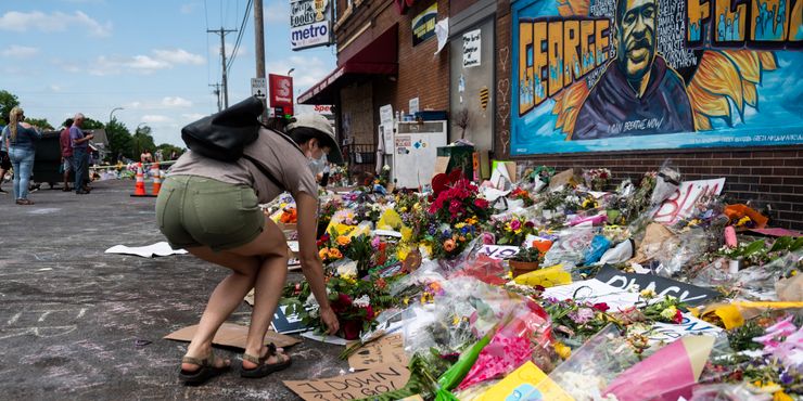 A woman leaves flowers at the site where George Floyd died May 25 while in police custody, in Minneapolis, Minnesota. 