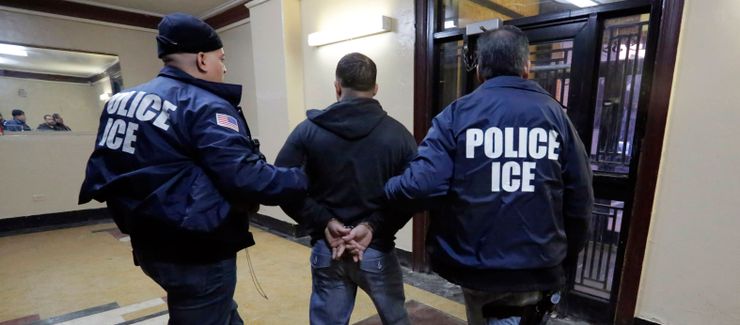 Immigration and Customs Enforcement officers escort a man out of an apartment building in the Bronx, N.Y., in 2015.