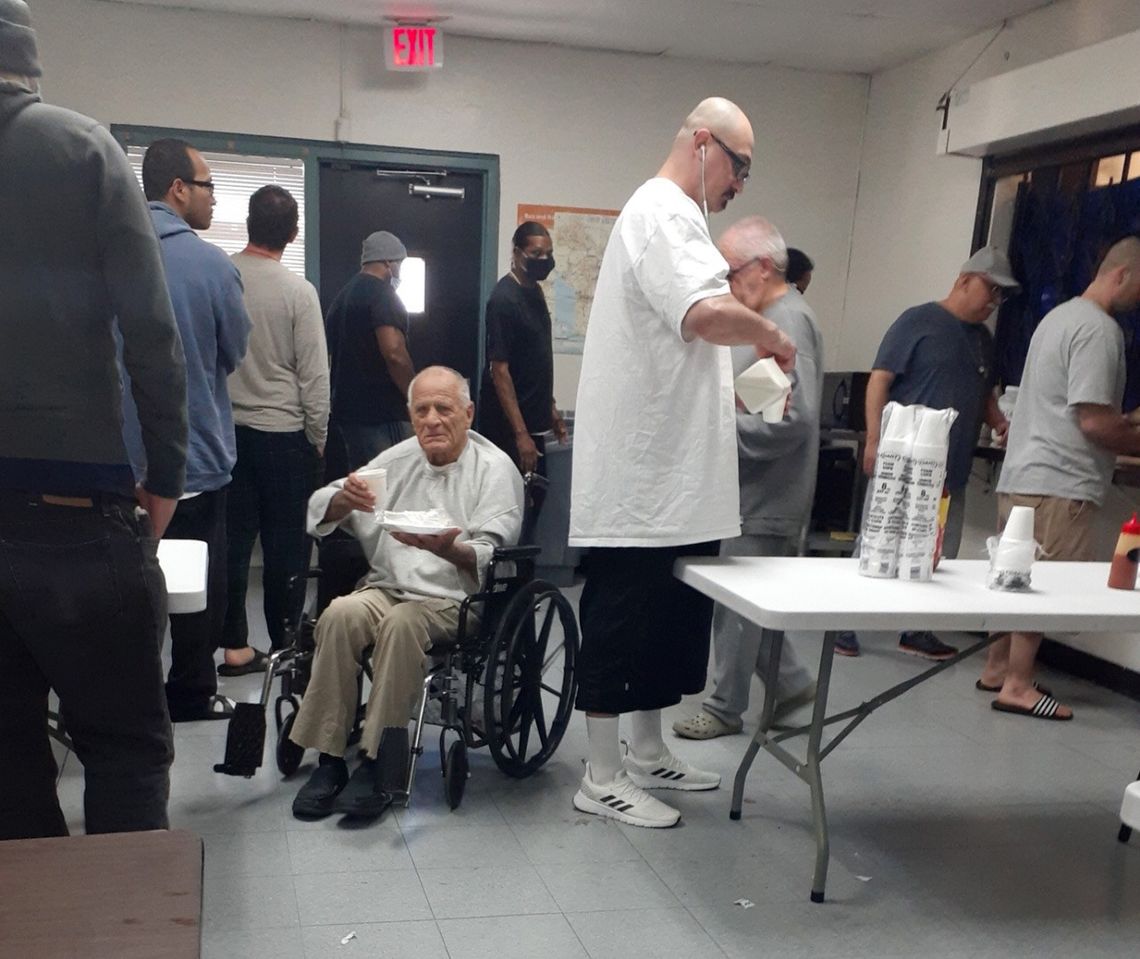 Few residents of Orion House wear masks as they line up for a meal at the federal halfway house in Van Nuys, California.