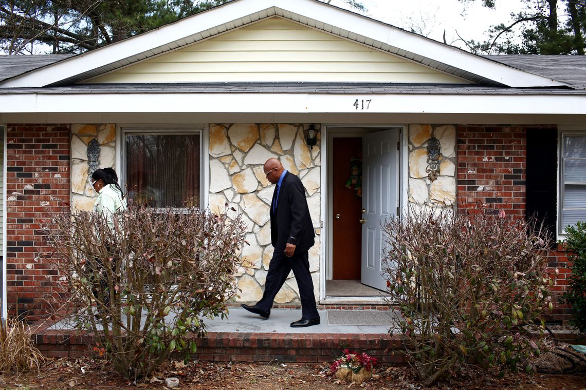 Leon Brown walks behind his sister, Geraldine Brown, outside of a home they shared with several family members in Fayetteville, N.C., after his release from prison.