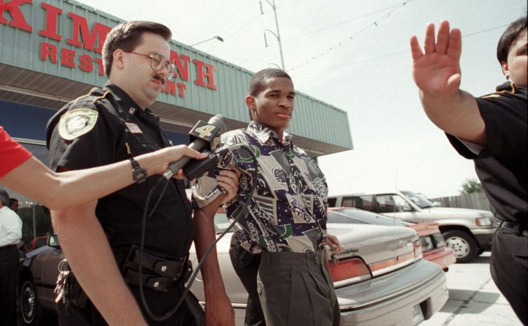 Sheriff’s deputies lead Rogers Lacaze out of the Kim Anh restaurant after Lacaze, the judge, jury, and attorneys visited the scene of a triple homicide in 1995.