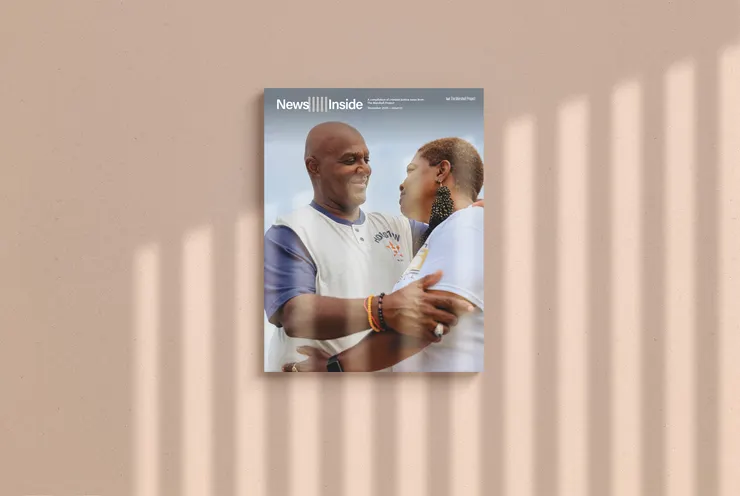 A magazine called News Inside set against a grainy tan backdrop. Light refracted through prison bars shines onto the magazine.