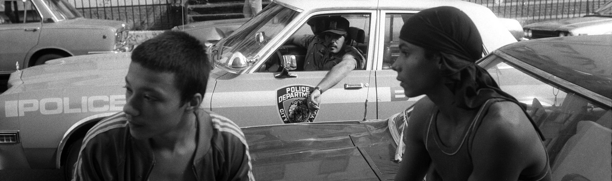 New York City police officers stop to observe two young people, who were not selling drugs but were hanging out on a known drug corner in the Bronx in the 1980s.