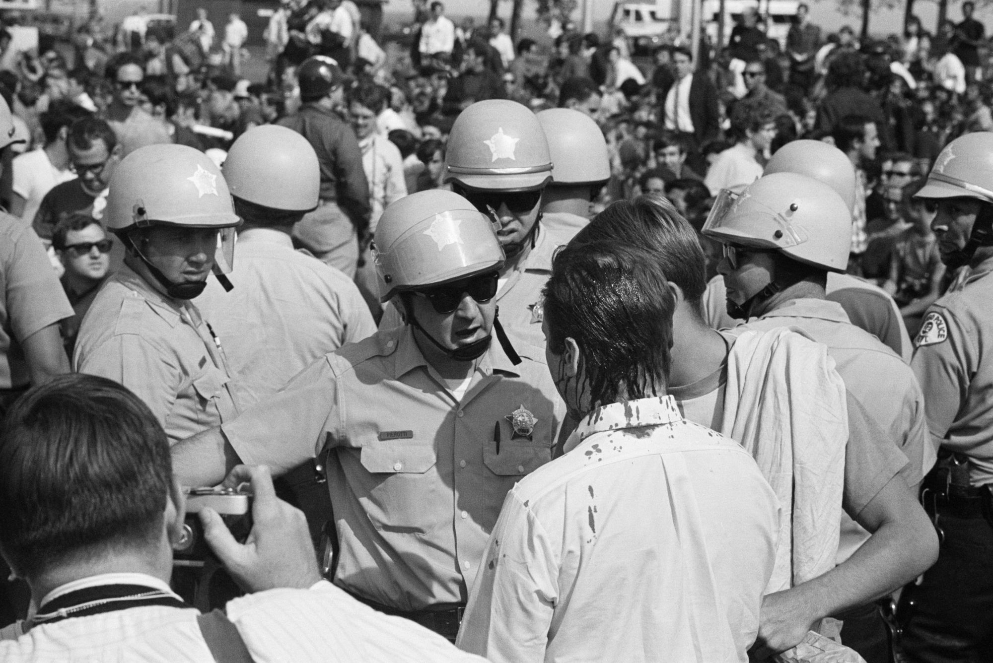 Police confront an anti-war demonstrator, bleeding from the top of his head, who was preparing for a march on the Democratic National Convention in 1968. 