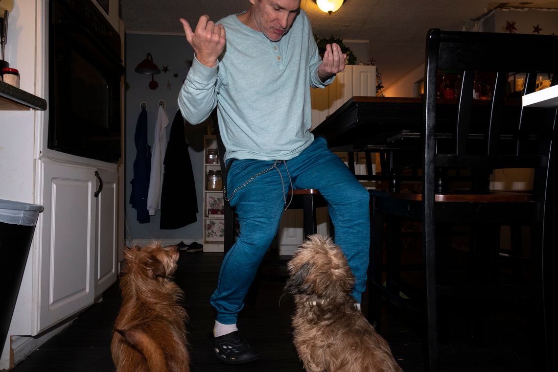 Chuck at home with his mother’s dogs. His injury keeps him from living on his own, but he dreams of buying a motor home and road-tripping across the country.