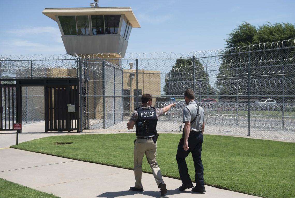 A police officer and a correctional officer patrol the entrance of the El Reno Federal Correctional Institution in El Reno, Oklahoma.