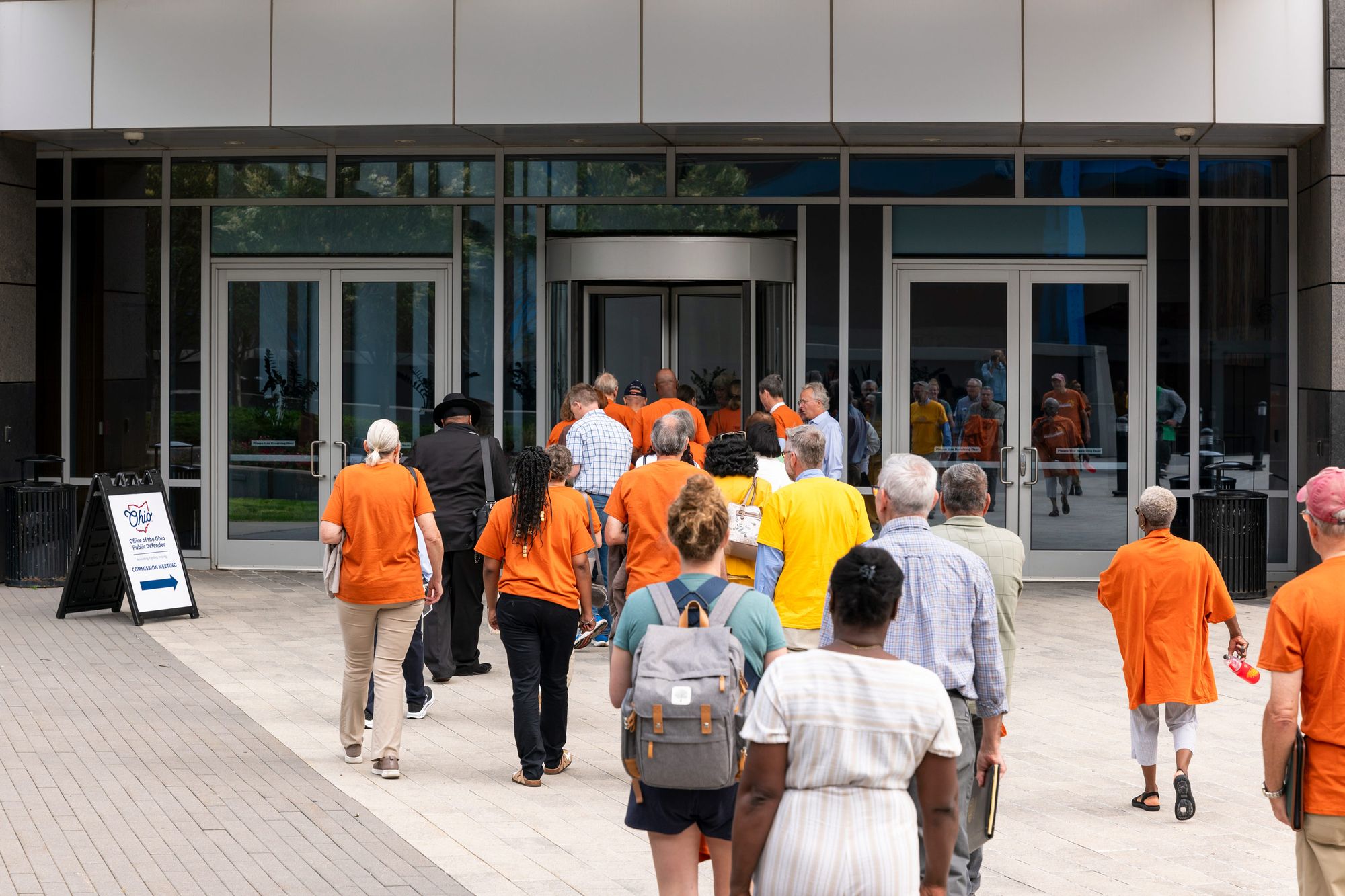 A photo of a group of people walking toward a building.