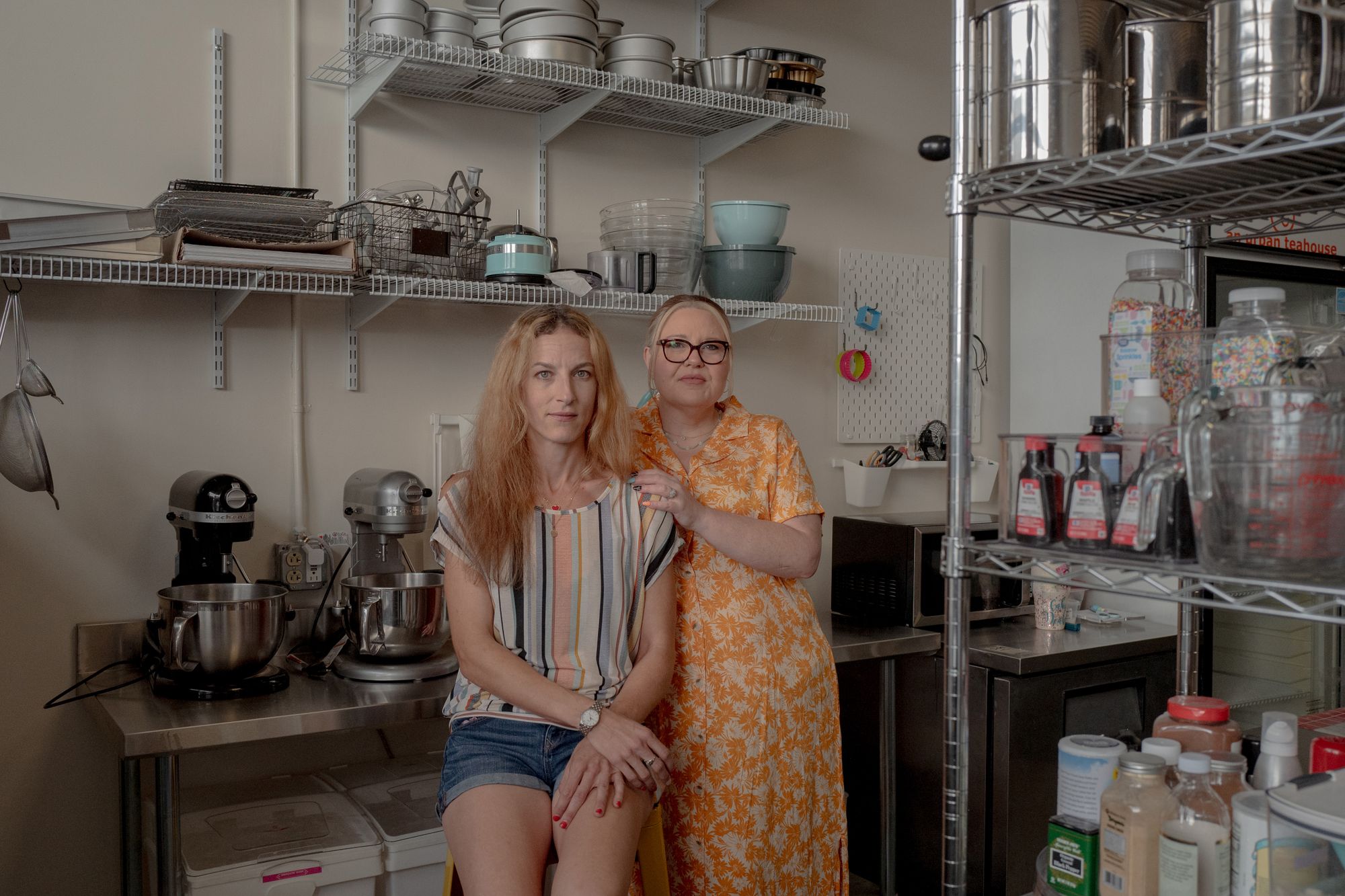 Two White women stand in the kitchen of a cafe.