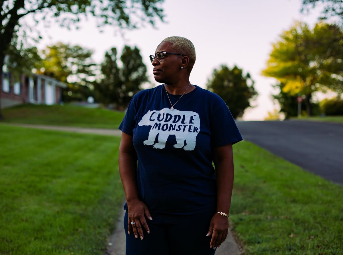 A Black woman with short blonde hair looks away while wearing a purple shirt with a polar bear on it and the words “cuddle monster.”