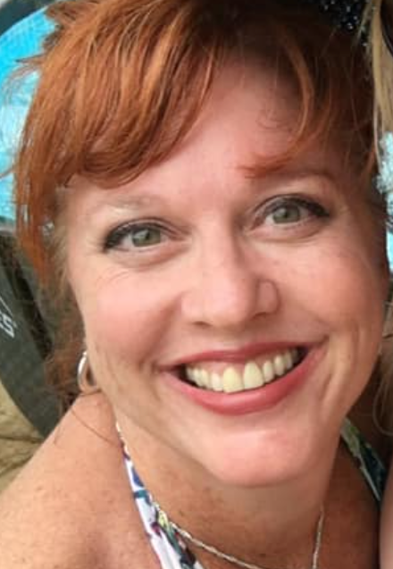 An image of a White woman with red hair smiling.