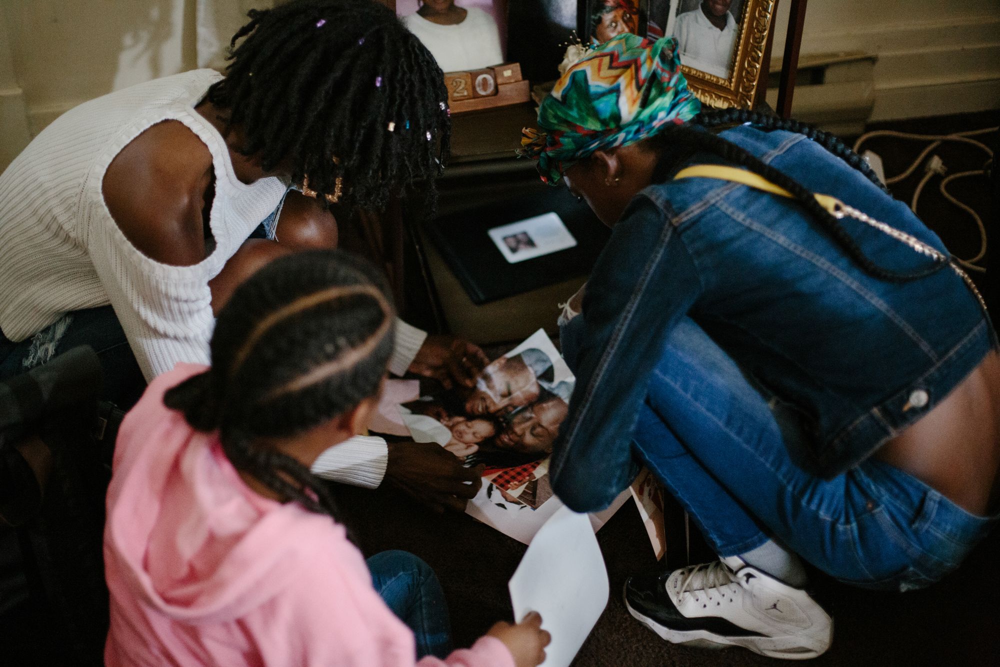 Chaney and her two daughters Aaliyah (middle), and Amijah (right), look at family images together in the home of Amijah’s father in Richmond, Virginia on Oct.7, 2020. 