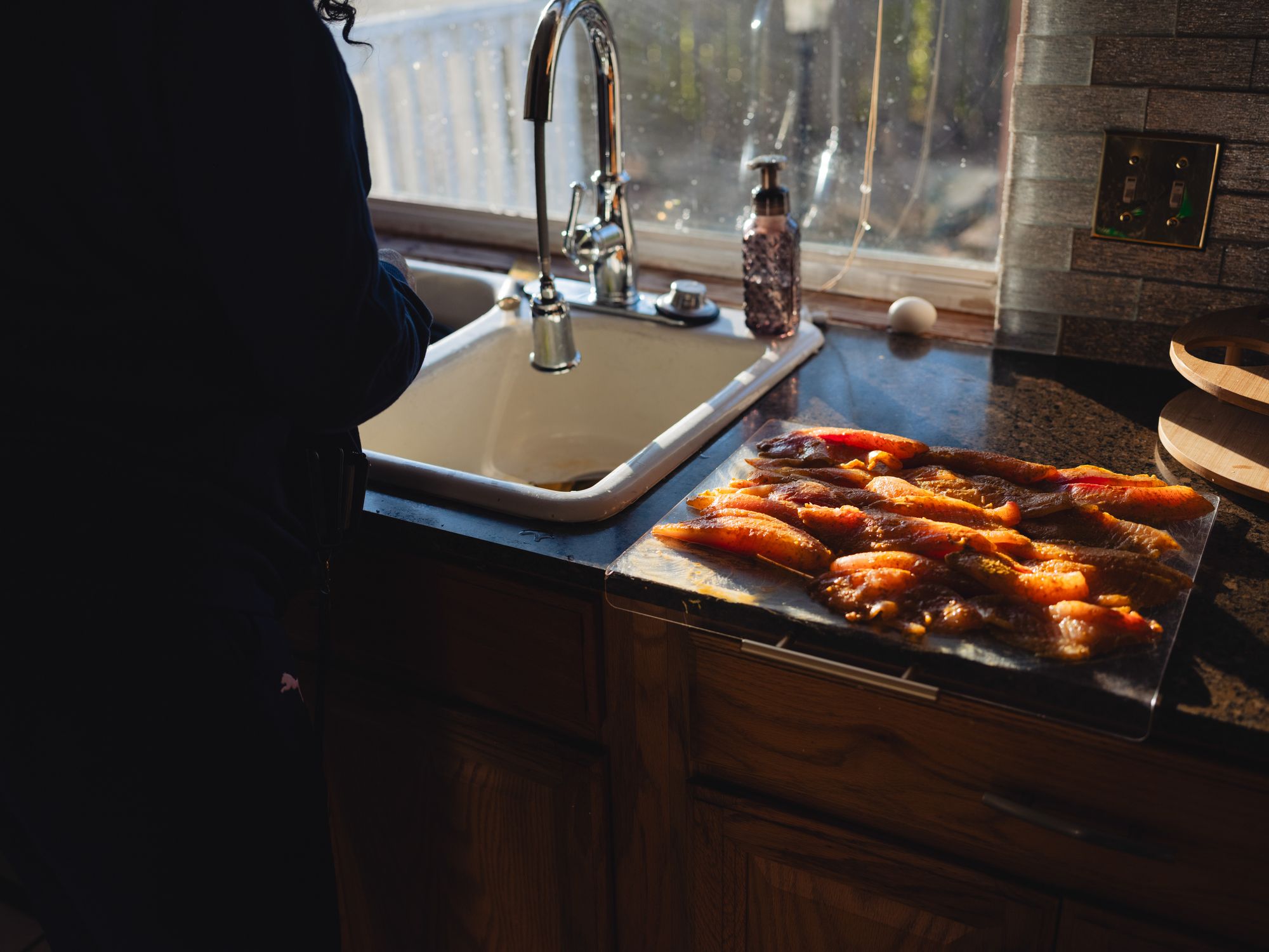 Raw catfish sits on a cutting board.
