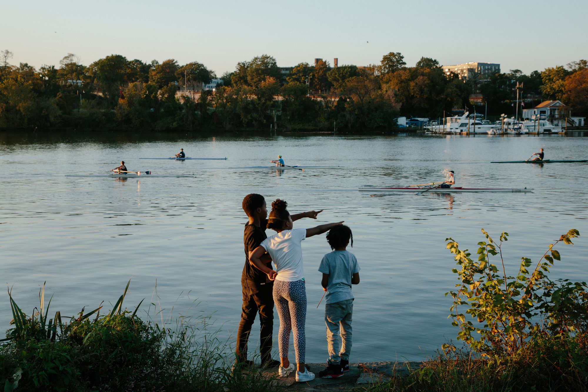 Chaney’s 9-year-old daughter, Aaliyah, looks on at rowers on the Anacostia River in Southeast D.C. with two neighbors as her mother instructs a trauma-informed yoga class for women on Oct. 21, 2020.