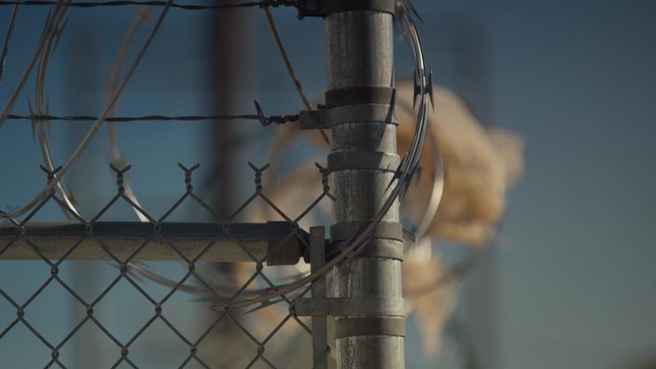 A gray chain-link fence topped with barbed wire outside an Oklahoma jail. 