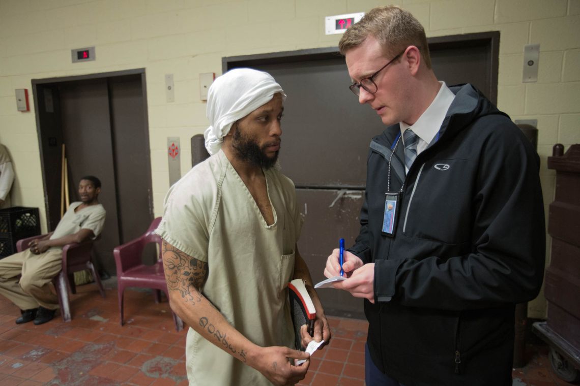 A man at the Cook County Jail's Division 4 consults with Robert Harmening, right, population manager for the Cook County Sheriff's Department.