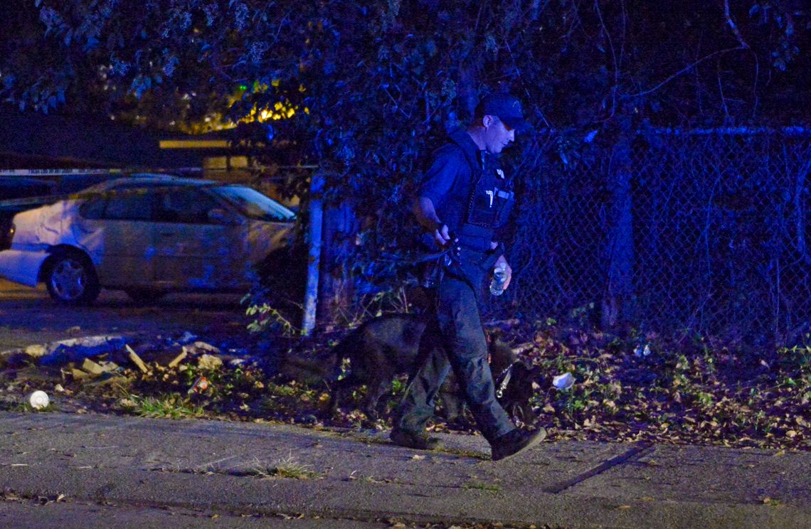 A Baton Rouge police officer and his K-9 at the scene of a shooting in October of 2017, in Baton Rouge, La.