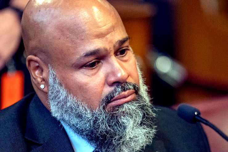 Steven Lopez, a 48-year-old man with medium-dark toned skin and wearing a suit, looks teary-eyed as he listens during a court hearing. 