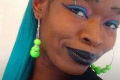 In a photo from her Facebook page, Tasha Grant, a Black woman, has teal hair and wears hoop earrings. 