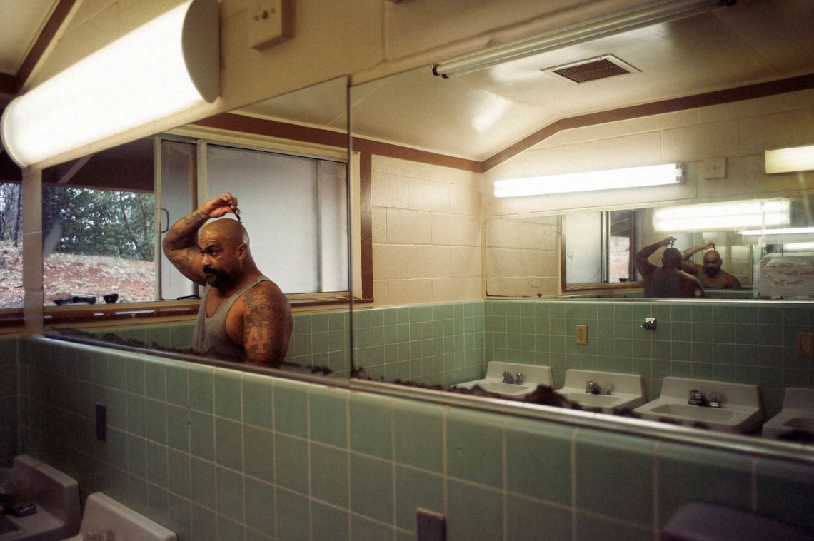 Carlos Marin shaves his head in a slow moment between jobs at the Growlersburg Conservation Camp in November, 2016. Roughly 3,800 inmates in the state’s prison system are on the front lines of active wild fires this fall.