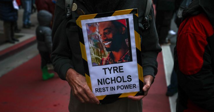 A closeup of Black hands holding a sign with a picture of Tyre Nichols, a Black man, with words underneath that read "Tyre Nichols, Rest in Power."