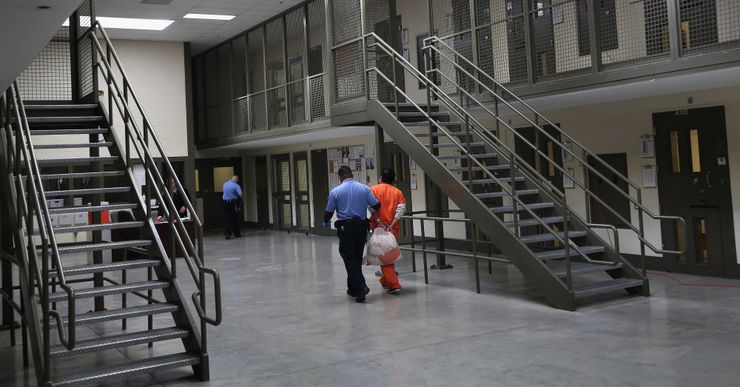 A guard escorts an immigrant detainee at the Adelanto Detention Facility in 2013 in Adelanto, Calif.