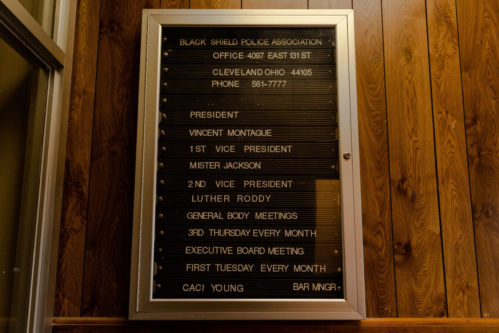 A sign hanging on a wooden wall showing the names of Black Shield President Vincent Montague and First Vice President Mister Jackson