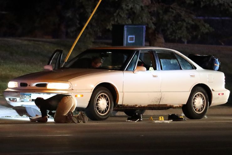 Investigators search a car at the scene where Philando Castile was shot to death by a Minnesota police officer during a traffic stop.