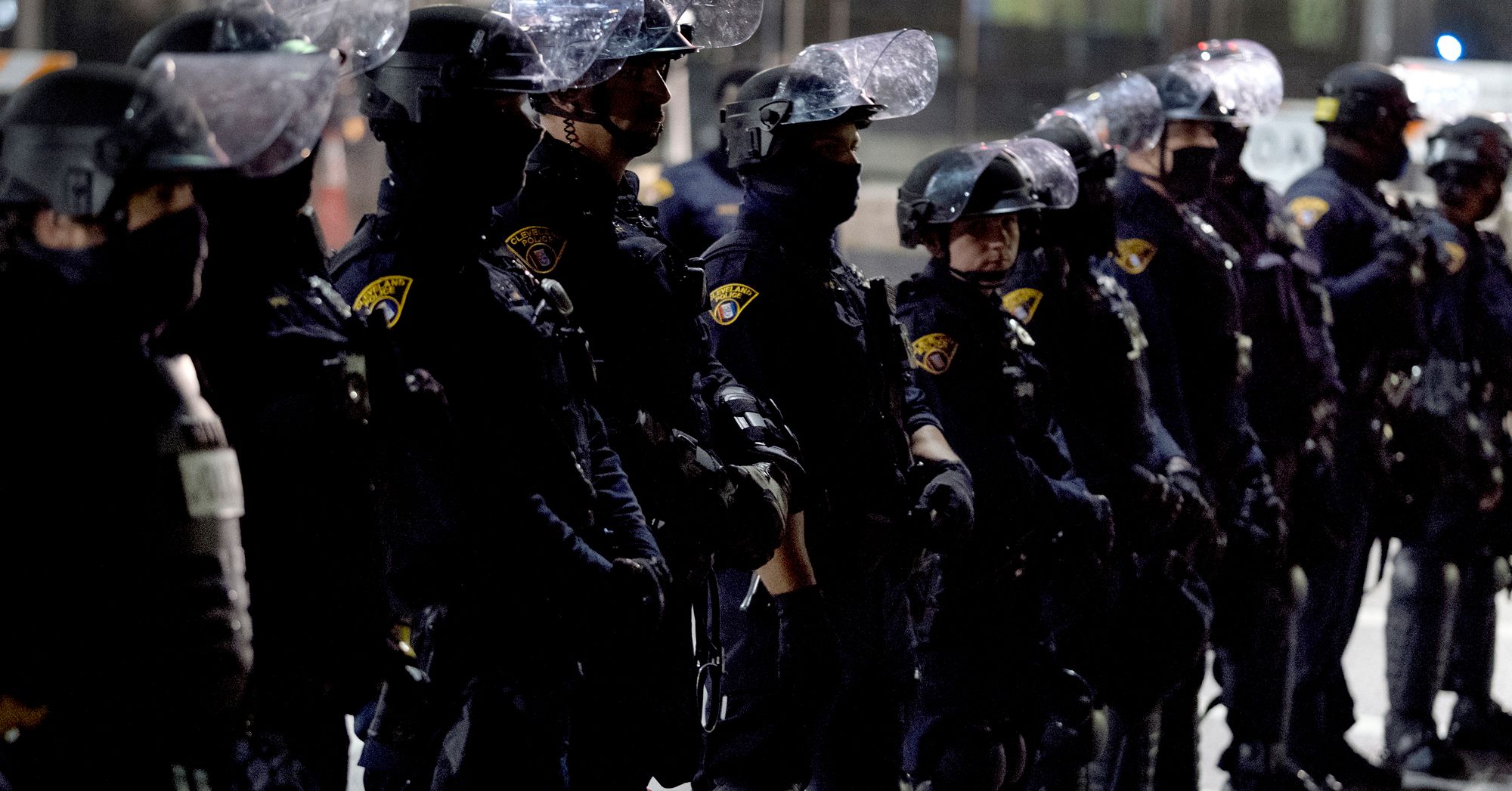 A photo shows a line of Cleveland police officers in riot gear outdoors.  