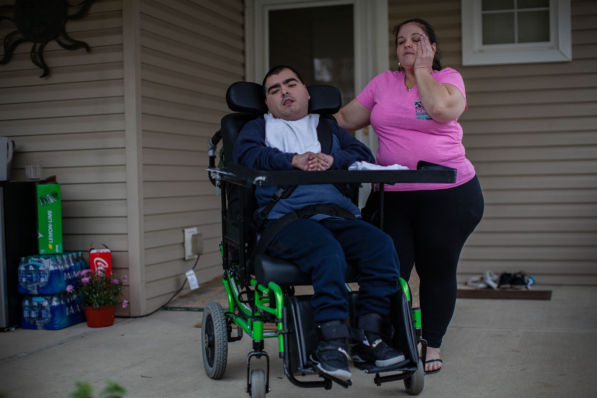 Seleste helped Juan prepare to catch the bus to a workshop at an adult day care center in Elyria in October 2019.