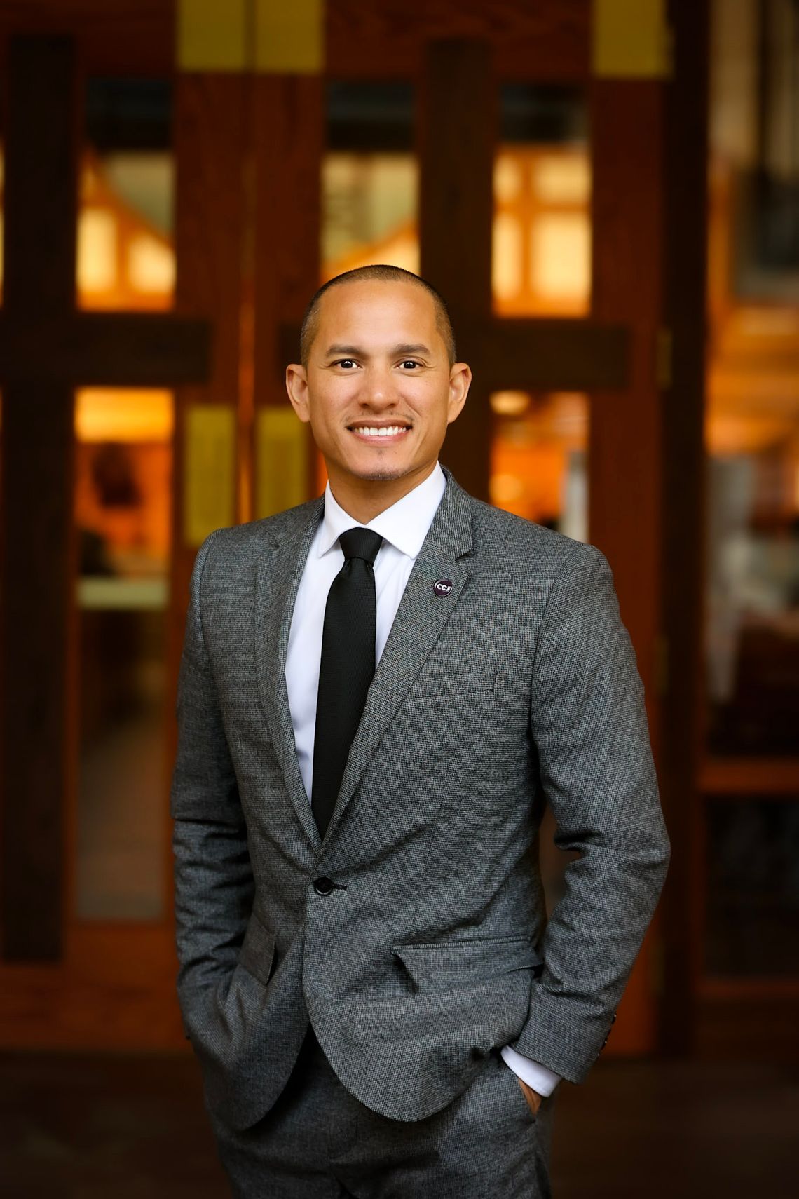 Khalil Cumberbatch, a man with medium-toned skin, wears a gray suit. 
