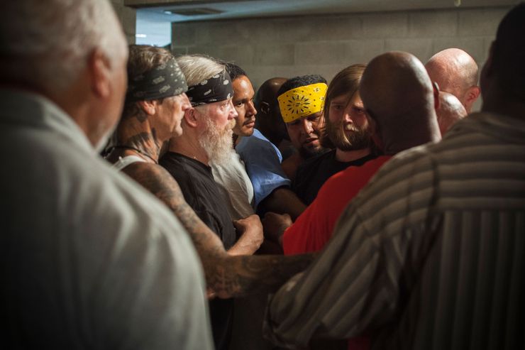 Chris Renton, an outside volunteer, is surrounded with support from inmates and other visitors during a group therapy session at Folsom State Prison in California.