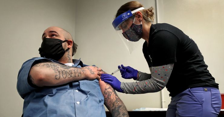 Christian Millett gets the first of two COVID-19 vaccine shots from Alyssa Dobbs, a contractor in the medical department at the Worcester County House of Corrections in West Boylston, Mass., in January. 