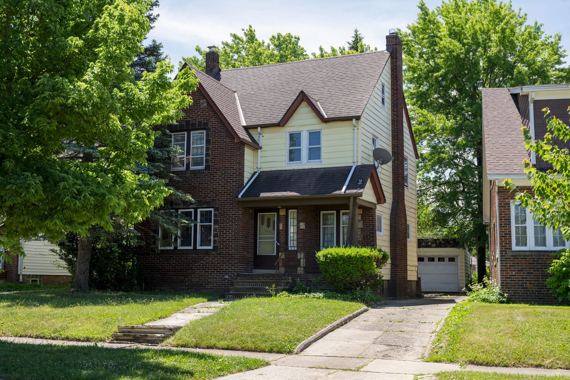 A photo shows a brick home with a grass lawn. 