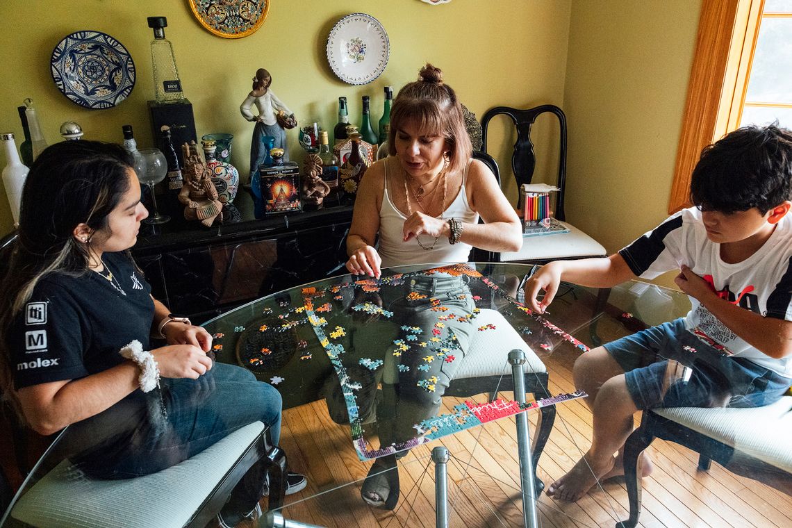 Perez and her children, Isabella and Xavier, work on a puzzle at home in Schaumburg, Ill. 