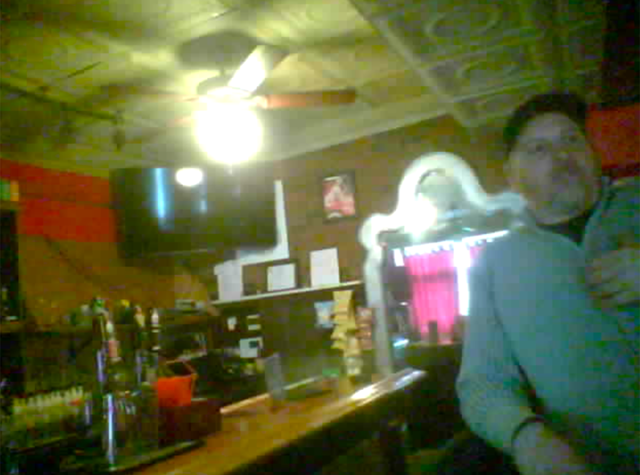 Andrew Long, a White man, wearing a baseball cap, sitting at the bar while facing in the direction of the camera. 