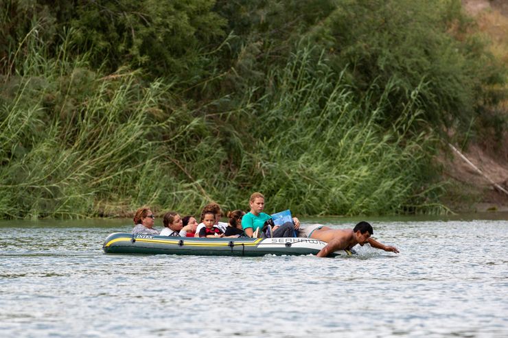 Migrants cross the Rio Grande river on a raft paddled by a “coyote,” a smuggler, shortly before being apprehended by the Border Patrol near McAllen in September. Under zero tolerance, any adult caught crossing illegally, except parents with children, can be sent to federal court for prosecution of the crime of illegal entry. 

