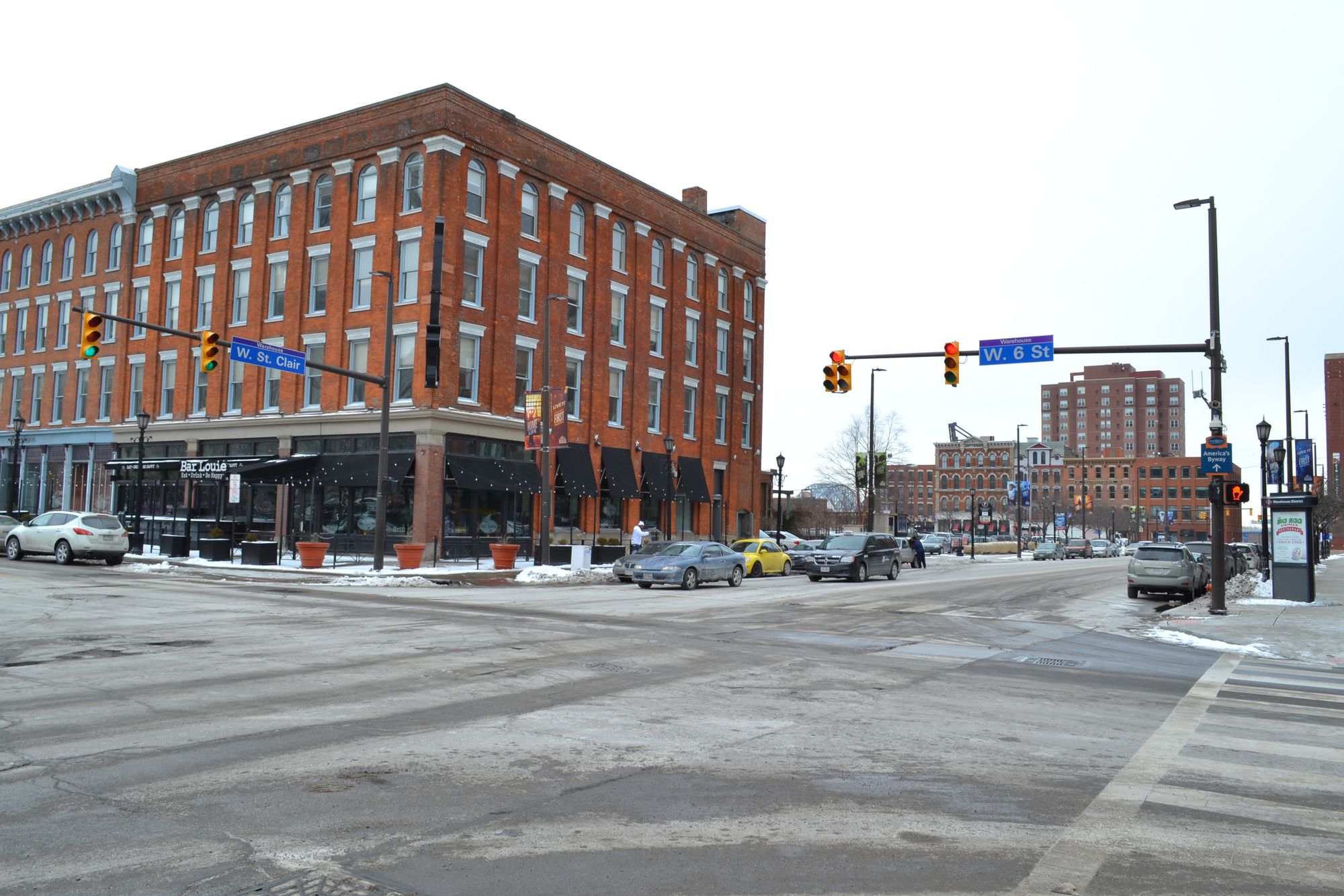 A view of the intersection, with a red building on the left side. 
