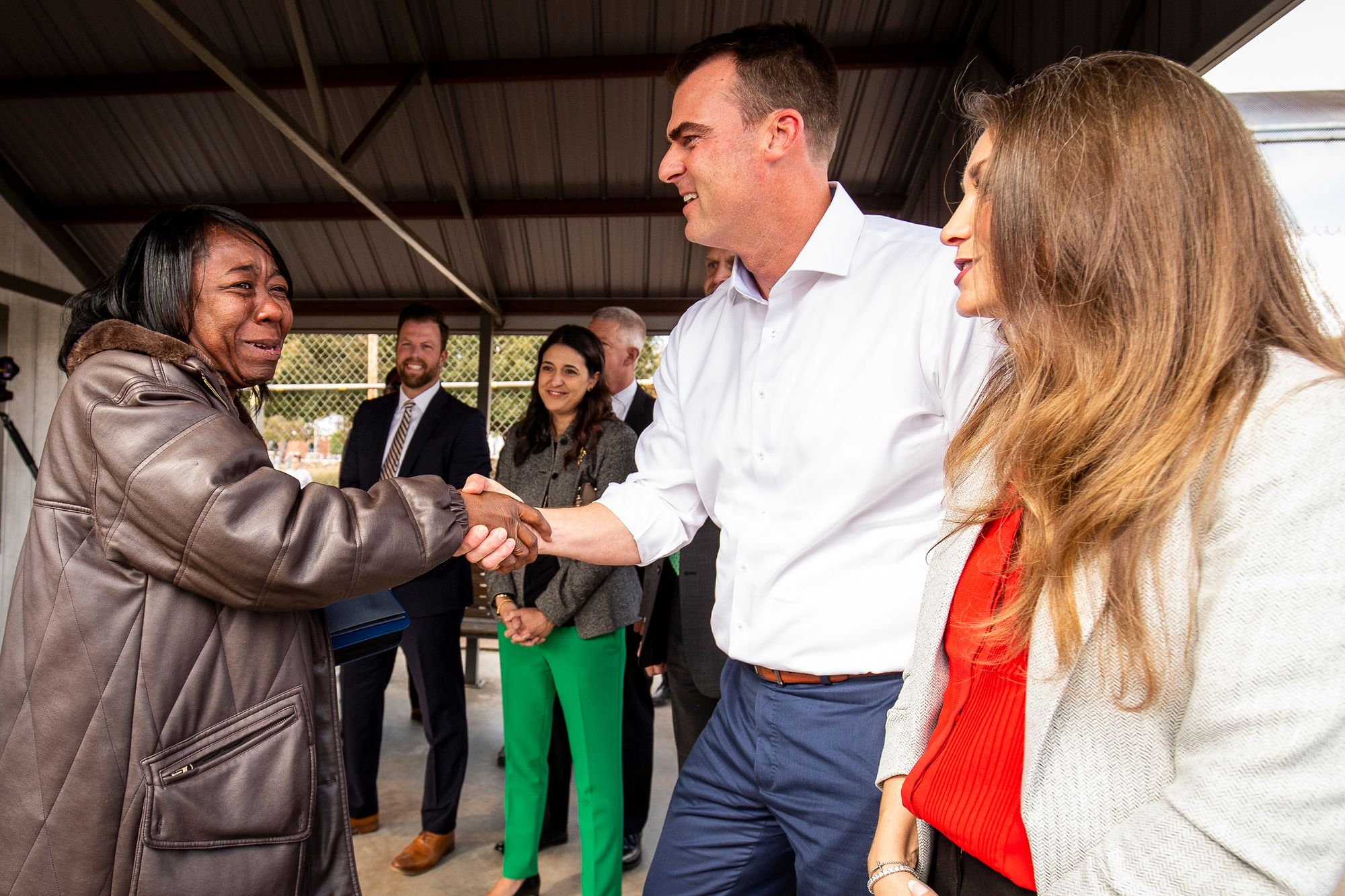 Snider shakes hands with Oklahoma Gov. Kevin Stitt as she steps out of the prison gate.