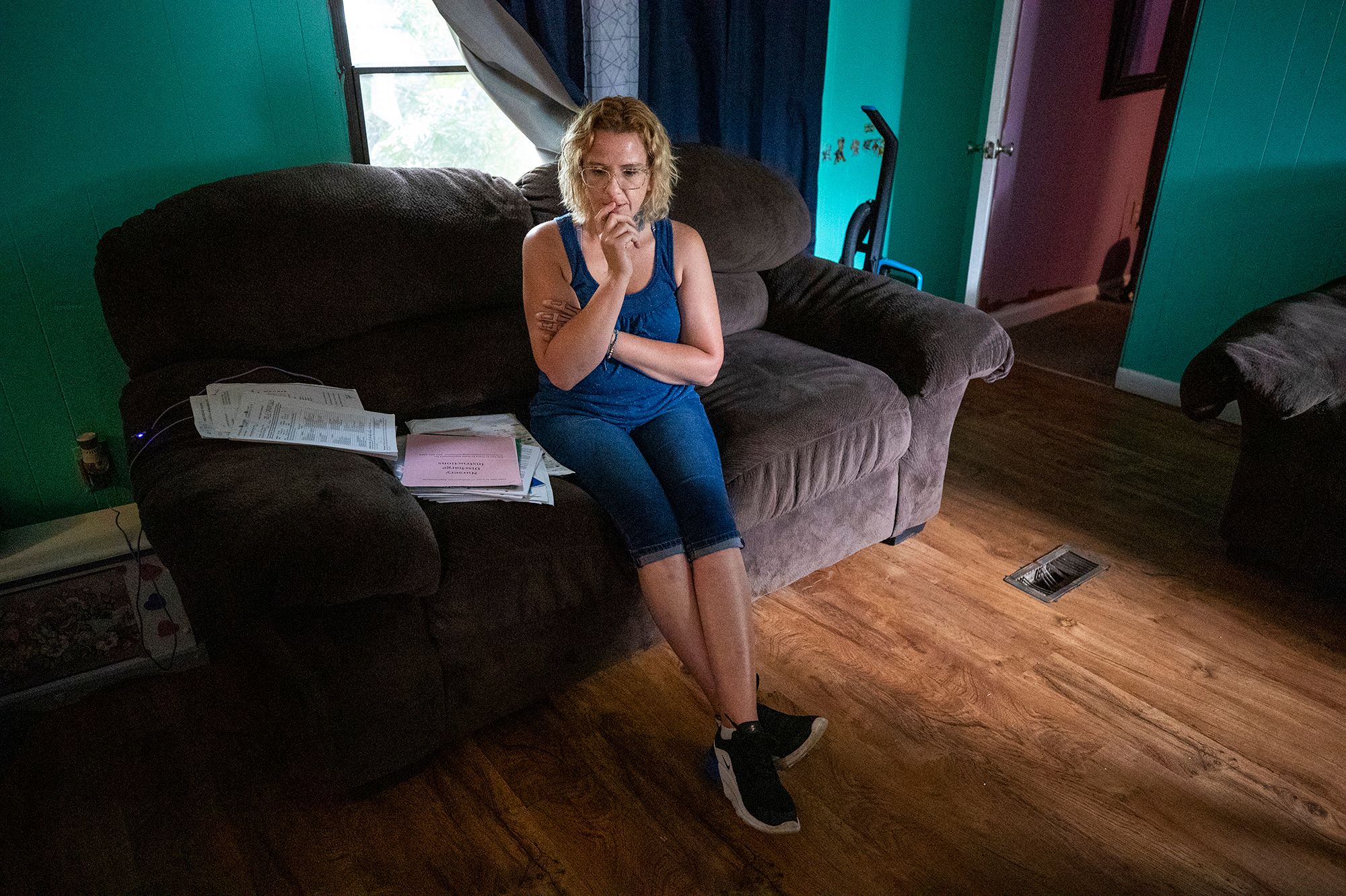 Jessica Jackson goes through a pile of photos and paperwork that documented her life before and after her parental rights were taken away, while sitting in her living room in Conway, S.C. on  August 11, 2023. Jackson tested positive for drugs while she was pregnant with her daughter. Under South Carolina policies, she ended up losing her parental rights and was placed on a child abuse registry. Only one of her children lives nearby, with the others living in other states. 