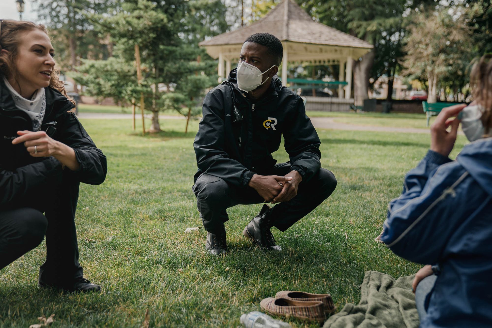 Crisis responders Aana Sundling and Chris Jones visit an unhoused community member in Olympia, Wash., to let them know about a potential shelter opportunity, in July 2020.
