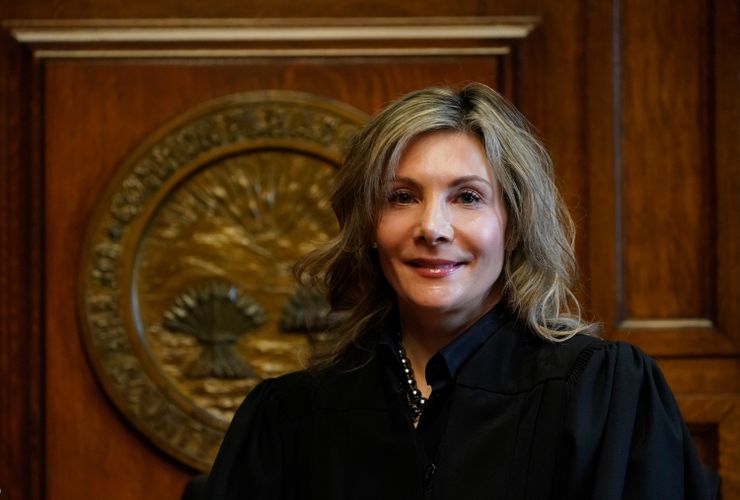 Celebrezze, a White woman with dark blonde hair, wears a black judge's robe.  
