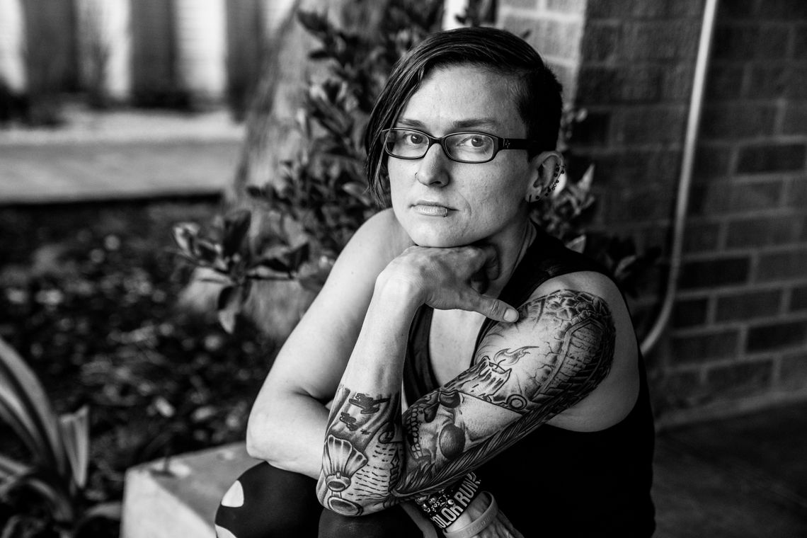 The author, a woman with short brown hair and glasses, sits on a step. 