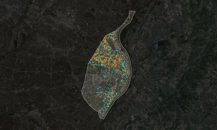 Aerial view of St. Louis, Missouri, with nearly 2,000 orange and cyan dots overlaid to represent unsolved and solved homicide cases over the past decade.