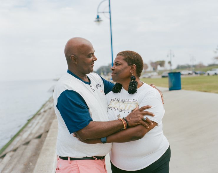 Raymond Flanks, a Black man, and Cassandra Delpit, a Black woman, embrace each other by Lake Pontchartrain.