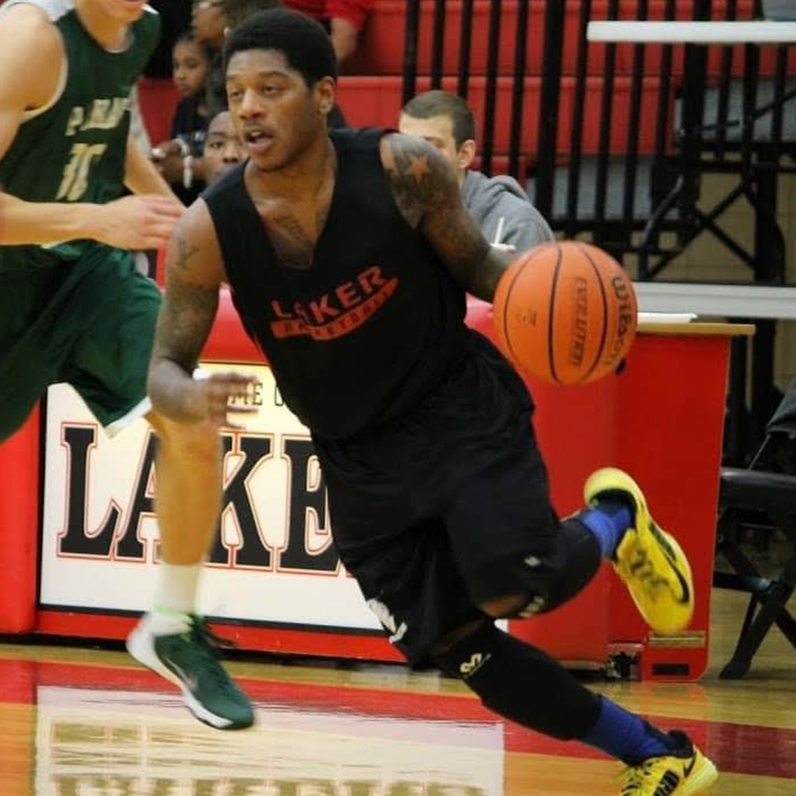 A Black man playing college basketball.