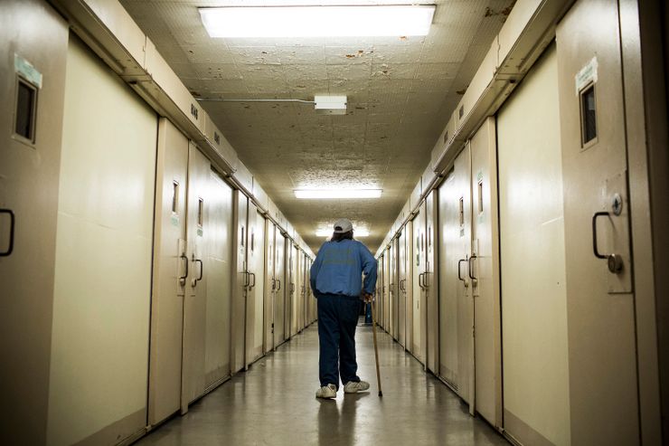 SAN LUIS OBISPO, CA - DECEMBER 19: (Editorial Use Only)  Frank Fuller, age 66, walks back to his prison cell after taking medication at California Men’s Colony prison on December 19, 2013 in San Luis Obispo, California. Fuller is helped through his daily life by the Gold Coats program, a volunteer care program where healthy prisoners care for elderly prisoners who either need general assistance with mobility and every day life or who also struggle with Alzheimer’s and dementia. The program, the first of it’s kind in the country, has existed for approximately 25 years. Fuller is serving a 35-years-to-life sentence; he has been incarcerated since 1990. He has been in the Gold Coats program for over six years. He says he is serving time for the murder of his third wife, who he says he shot with a rifle in a drunken rage after learning she had been having an affair with another man. He has been diagnosed with Post Traumatic Stress Disorder from serving five years in the Navy in the Vietnam War; he also has Hepatitis C. Fuller, who took shrapnel in his legs from a mortar round, says he held many different positions while fighting in Vietnam, including being a machine gunner; he says he still suffers occasional flash backs. He says has served one other sentence for murdering a man with a .45 caliber gun in a fight. Between Vietnam and prison, he says he worked in the oil fields and in manufacturing.  (Photo by Andrew Burton/Getty Images)