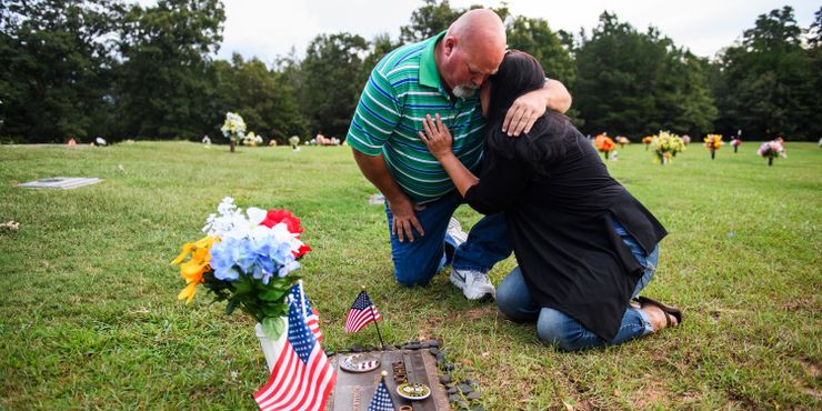 Kevin Johns comforts Kathy Bowling at their son Jared Johns’ grave at Cannon Memorial Park in Fountain Inn, South Carolina. 