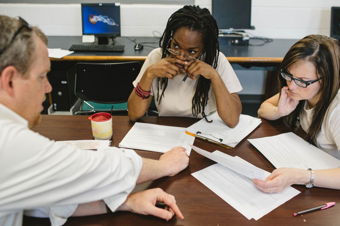 Andrew Falk, left, a senior fellow at the Sagamore Institute, works with Michelle Jones, center, and Natalie Medley, right, on a housing policy proposal at the Indiana Women's Prison.